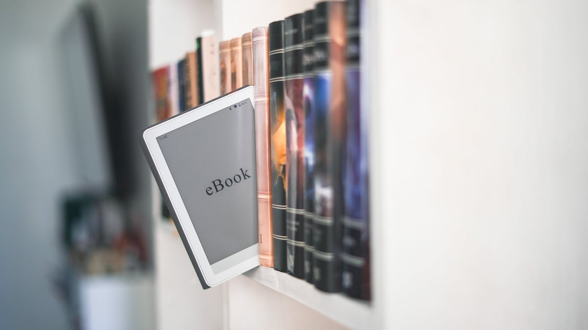 Ebook digital junto a libros impresos sobre biblioteca